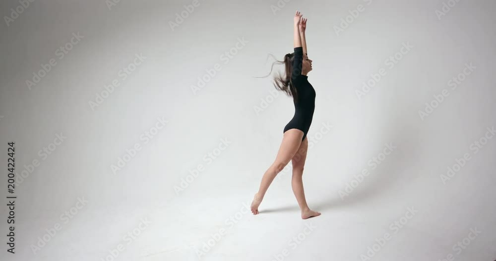 Young girl doing somersault Arab jump in studio Young girl doing somersault Arab jump in studio