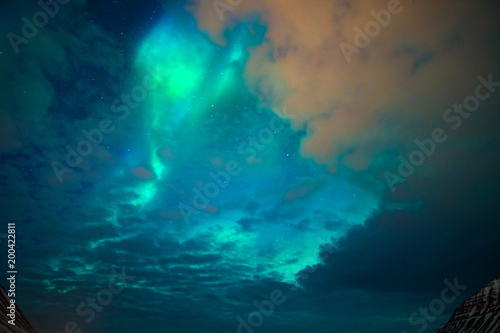 northern lights over the mountains and a cloudy sky © lakkot