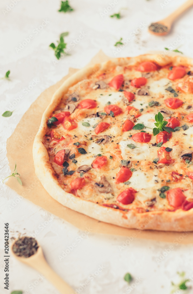 Margherita home made pizza with mushrooms on white table Margherita home made pizza with mushrooms on white table