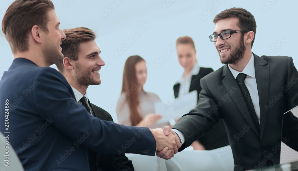 Partners concluding deal and shaking hands in the presence of te Partners concluding deal and shaking hands in the presence of te