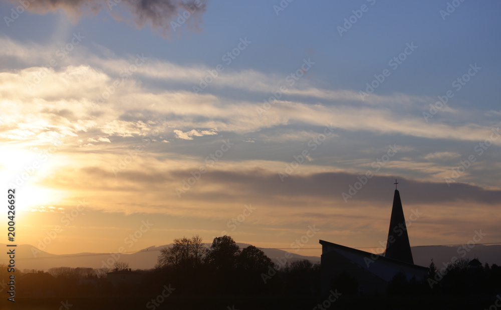 Landscape and church, cross silhouette on cloudy sunset sky Landscape and church, cross silhouette on cloudy sunset sky