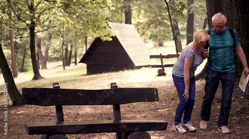 Senior couple walking in the park, woman having problem with leg
