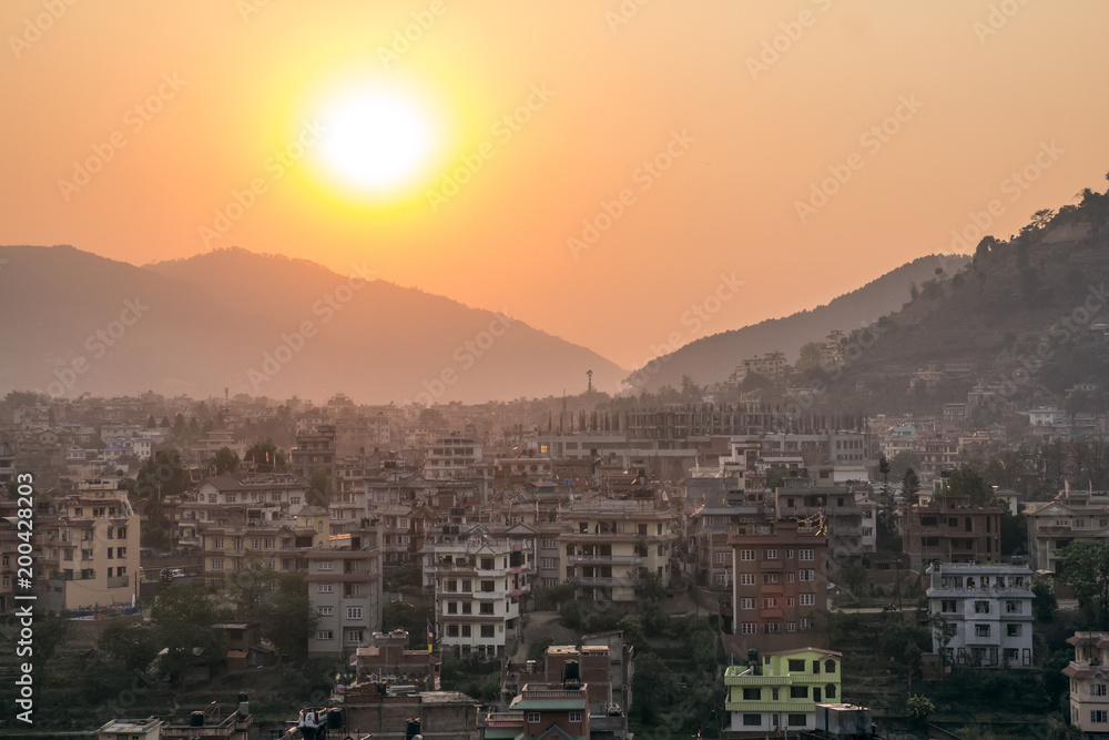 Sunset in Kathmandu valley, mountains and buildings in haze. Topview