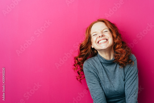 Fotografiet Young laughing woman against pink background