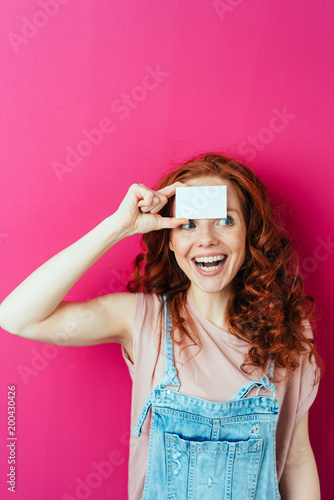 Young cheerful woman holding blank white card