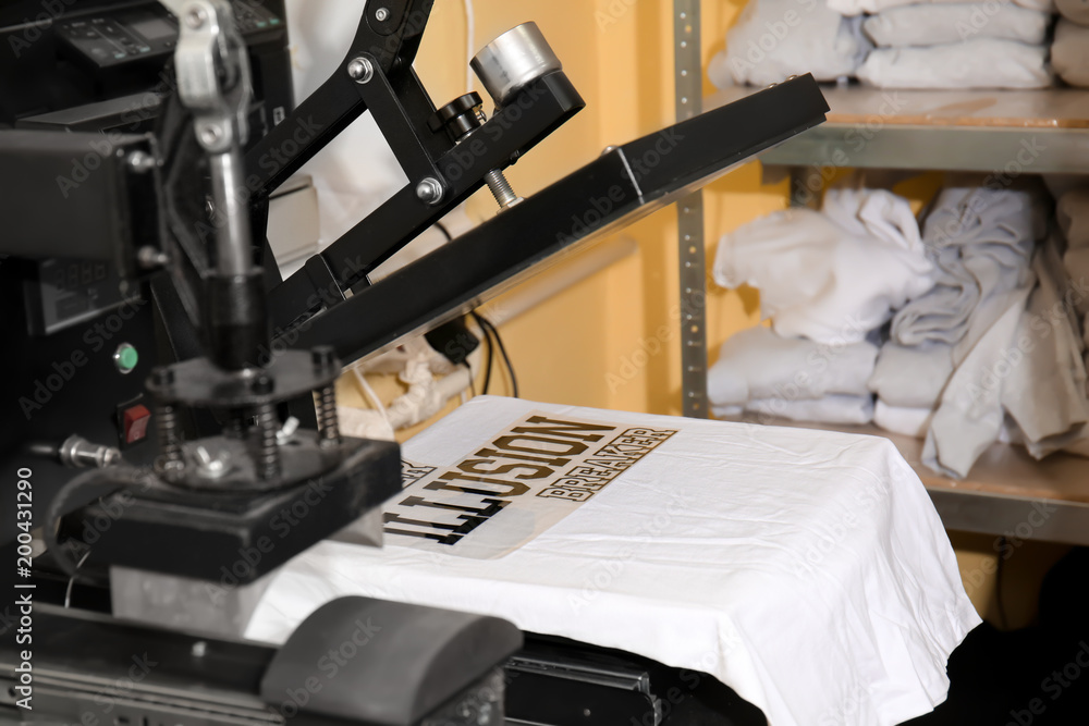 Modern printing machine with t-shirt at workplace - obrazy, fototapety, plakaty 