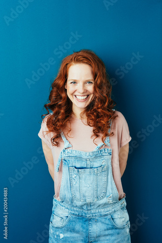 Obraz na plátne Happy cheerful young redhead woman in dungarees