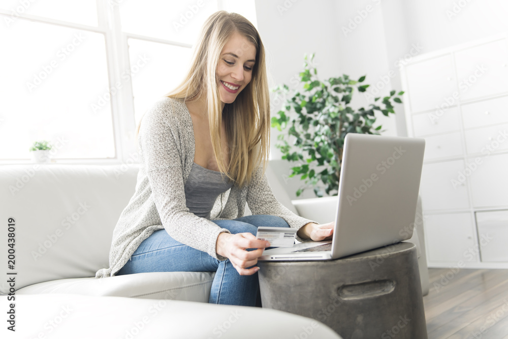 Fototapeta premium Young woman on a sofa on the living room