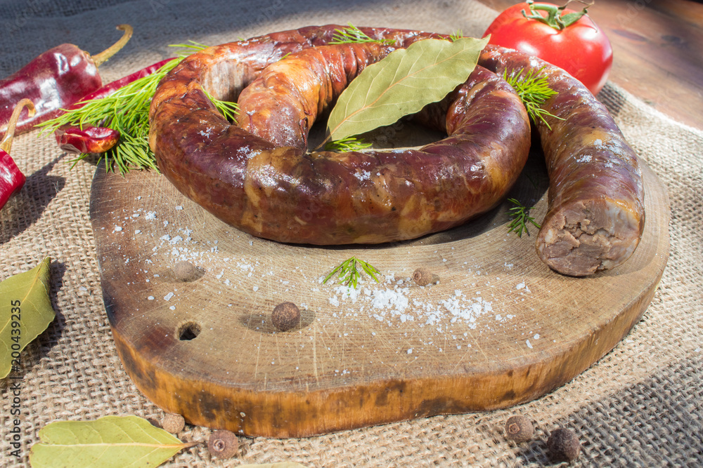 A ring of cooked sausage on the grill. A ring of cooked sausage on the grill.