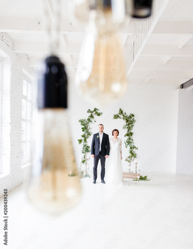 The bride and groom stand in the background under the lamp. The bride and groom stand in the background under the lamp.