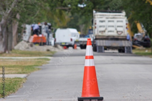 Traffic cone blocking street with underground construction equipment © Lawr