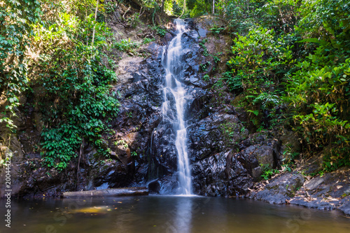 Beautiful waterfall in rainforest, soft water of the stream in the natural park. Long exposure.