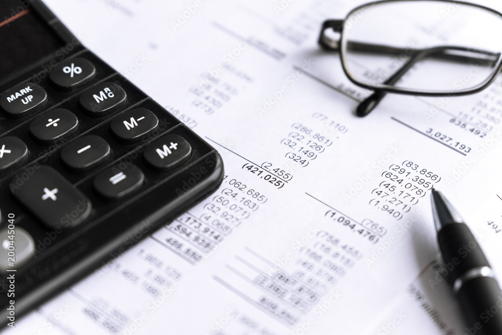 Investment and Financial analysis and reporting concept with Calculator, glass and pen. focus in center, selective. Investment and Financial analysis and reporting concept with Calculator, glass and pen. focus in center, selective.