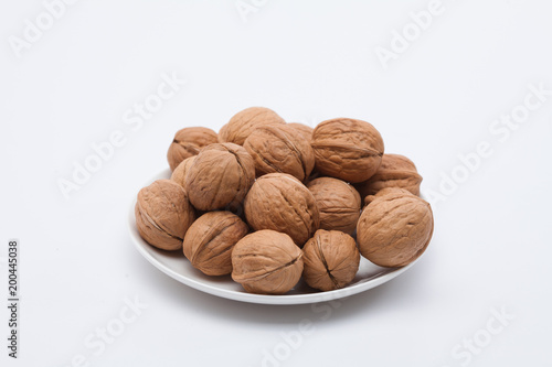 Walnuts on white dish on the white background 