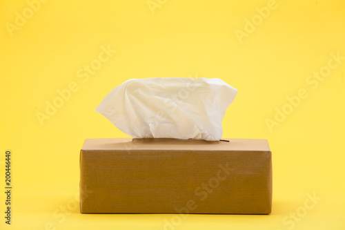 Paper tissues in brown box on yellow background
