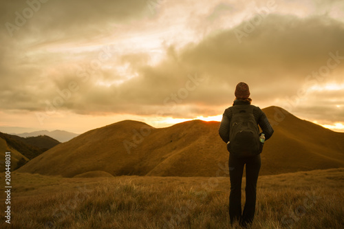 Female hiker standing on a mountain looking at the beautiful view. Location Philippines Mt Pulag.