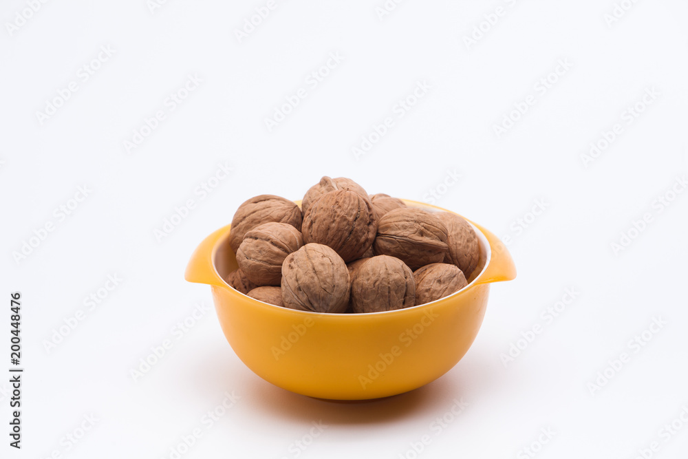Yellow bowl full of walnuts isolated Yellow bowl full of walnuts isolated