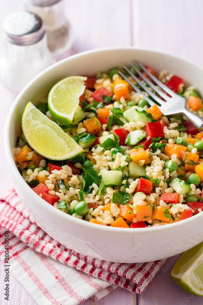 Fresh salad with bulgur and vegetables in bowl on wooden table Fresh salad with bulgur and vegetables in bowl on wooden table