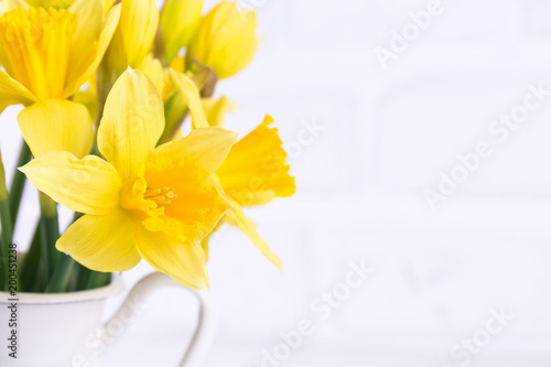Fototapeta Naklejka Na Ścianę i Meble -  Jar with narcissuses at the white background. Spring, mothers day and easter concept