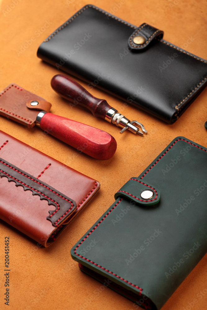 Set of hand made leather man wallet . Multi colored. Leather craft.On brown leather background.Top view Set of hand made leather man wallet . Multi colored. Leather craft.On brown leather background.Top view