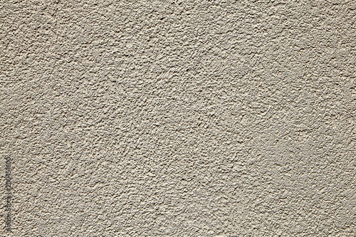 Seamless stippled beige stucco wall texture background.