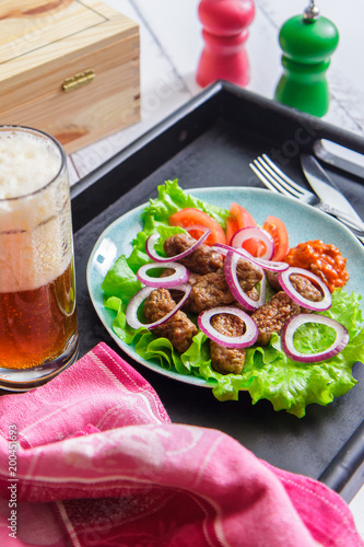 Chevapchichi with vegetables on a blue plate and beer. Croatian cuisine photo