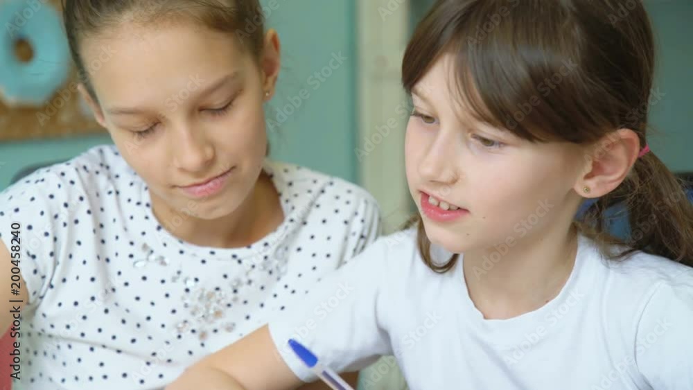 girl teaching her sister homework. Schoolgirl check exercise. pleasant work background girl teaching her sister homework. Schoolgirl check exercise. pleasant work background