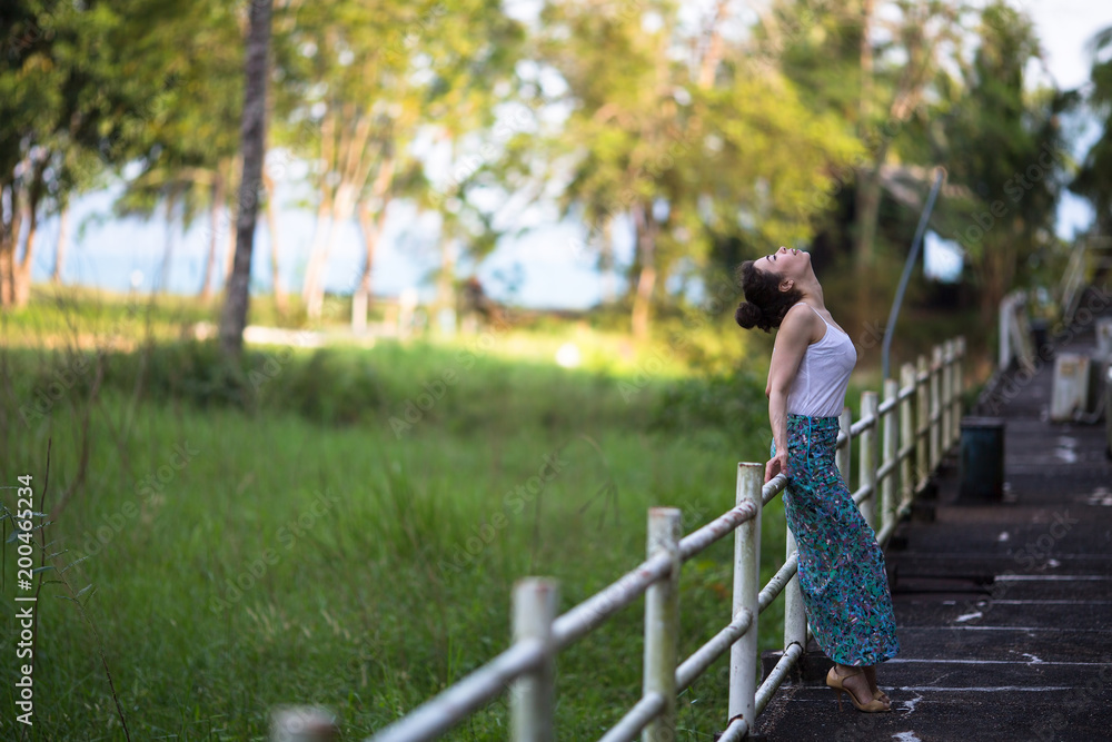 Fototapeta premium Fashionable girl of mixed race on an abandoned facility in the jungles of Asia.