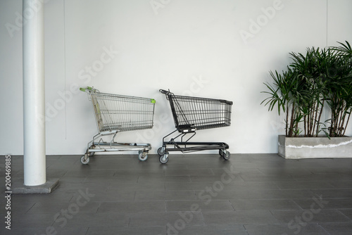 Black and silver shopping carts against the white wall in shopping mall © v74