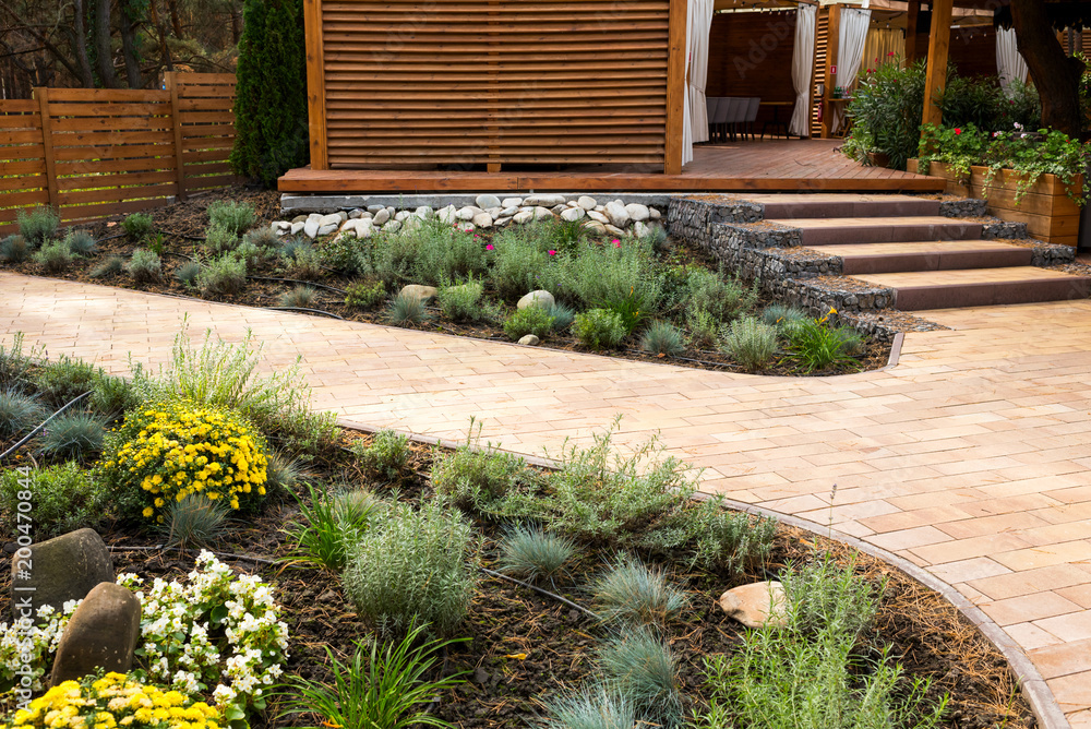 Obraz premium stone path with decorative bushes in the park