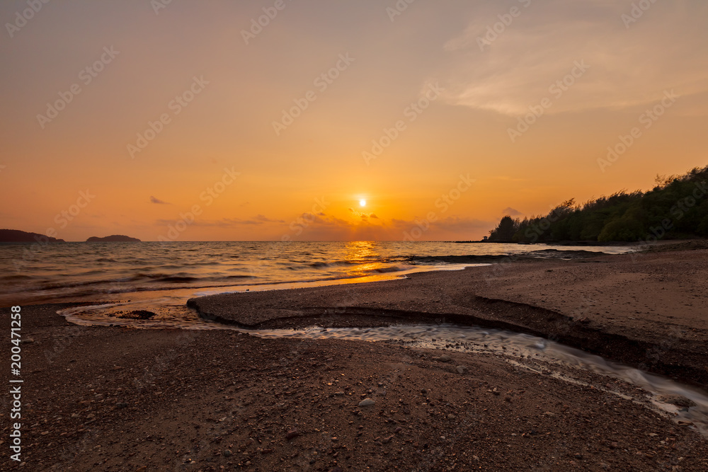 Golden evening sky at sunset, the river flows into the sea. Long Exposure Technique Golden evening sky at sunset, the river flows into the sea. Long Exposure Technique