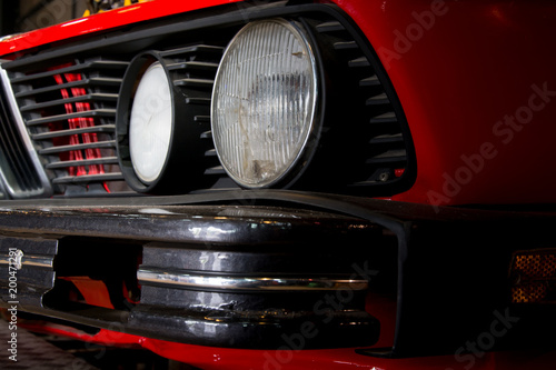 Close-up of headlights of red vintage car © tlovely
