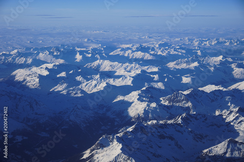 Bird's eye view of mountainscape covered in snow from an airplane