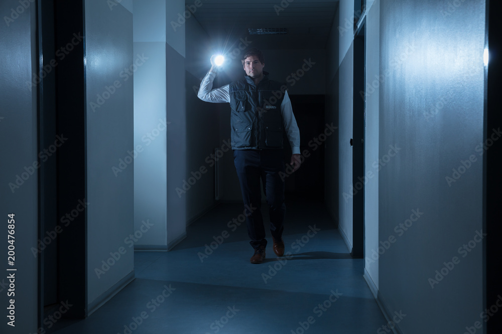 Fototapeta premium Security Guard Holding Flashlight