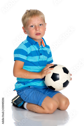 Little boy is playing with a soccer ball.