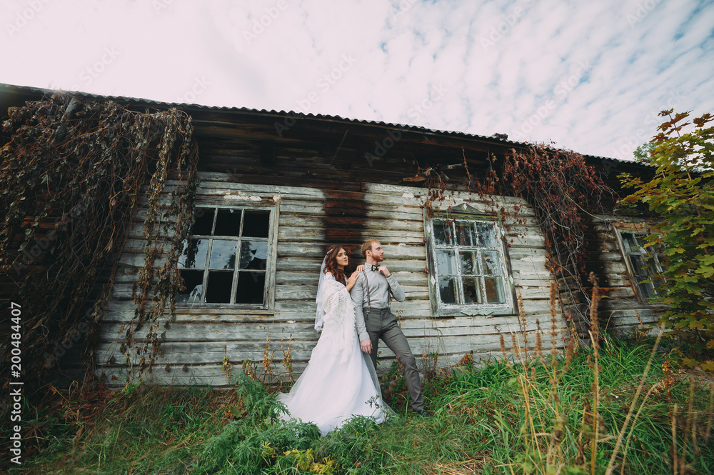 Fototapeta premium Bride and groom hugging in a forest near the horse in the autumn forest, wedding walk