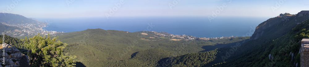 Stunning panoramic view opening to the mountains and the sea of the Crimean peninsula by a summer cloudless day.