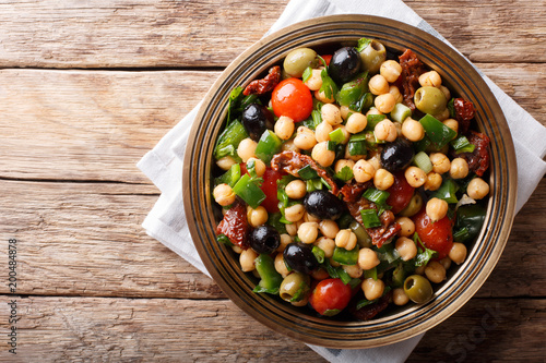 East balela salad with chickpeas, tomatoes, onions, olives and herbs closeup. Horizontal top view photo