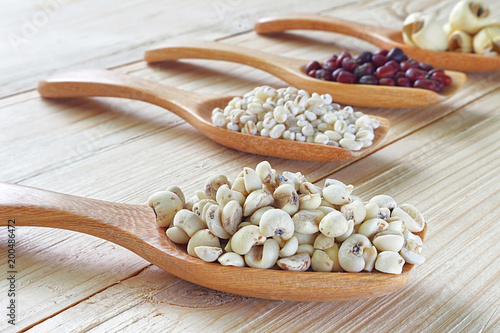 Mix cereal , soy beans , dry millet seed , red beans , lotus seed on spoon with backgeound wood table. photo