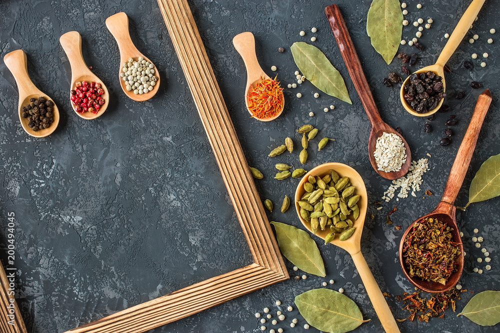 spices and herbs over black stone background