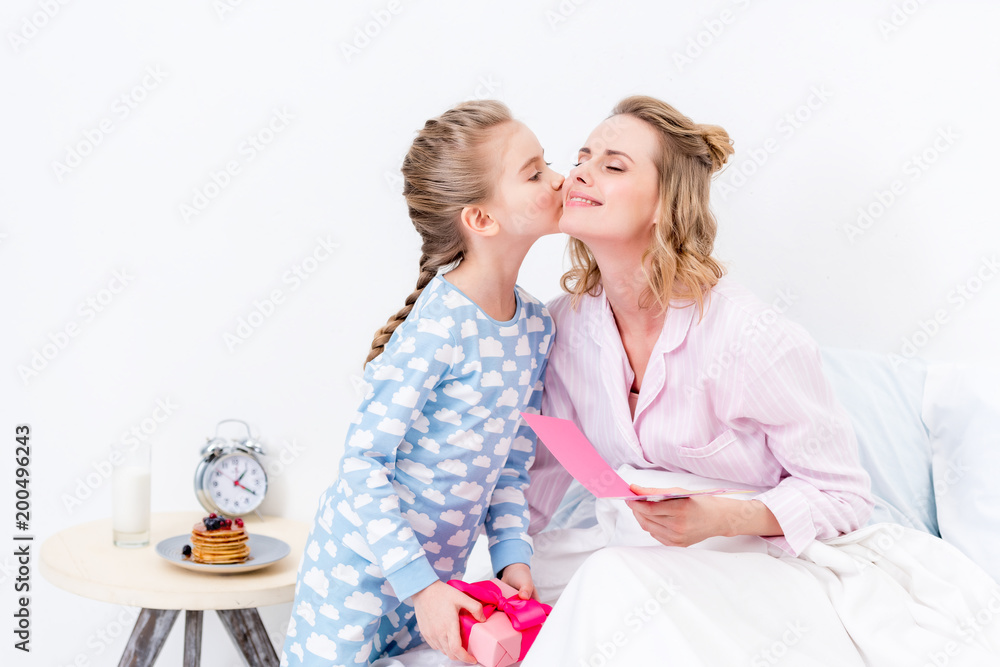 daughter kissing mother and greeting with happy mothers day