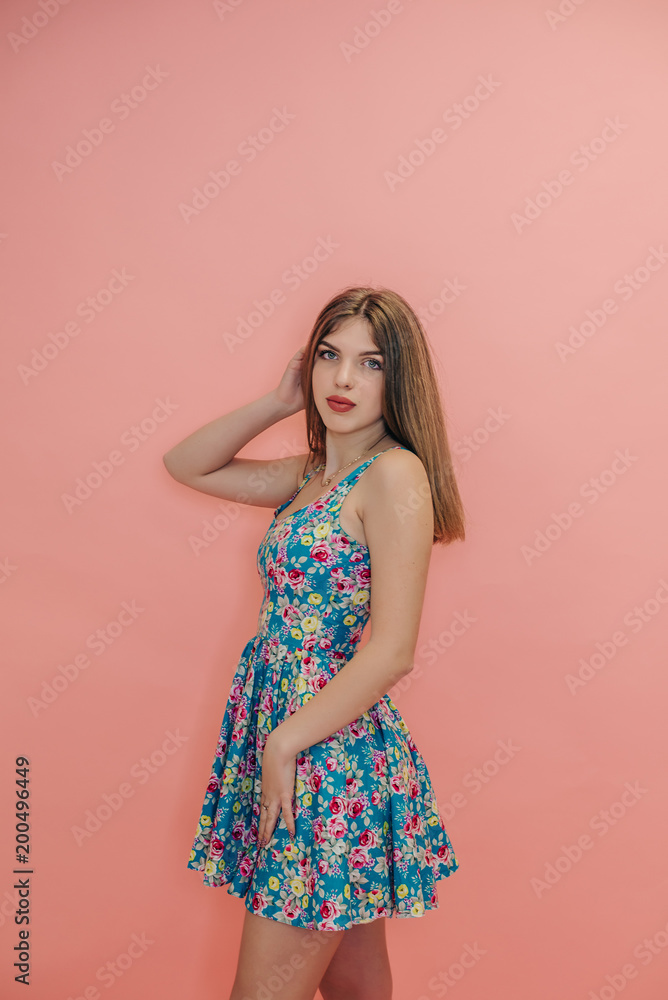 girl teenager, with beautiful hair, on a pink studio background, in a summer dress girl teenager, with beautiful hair, on a pink studio background, in a summer dress