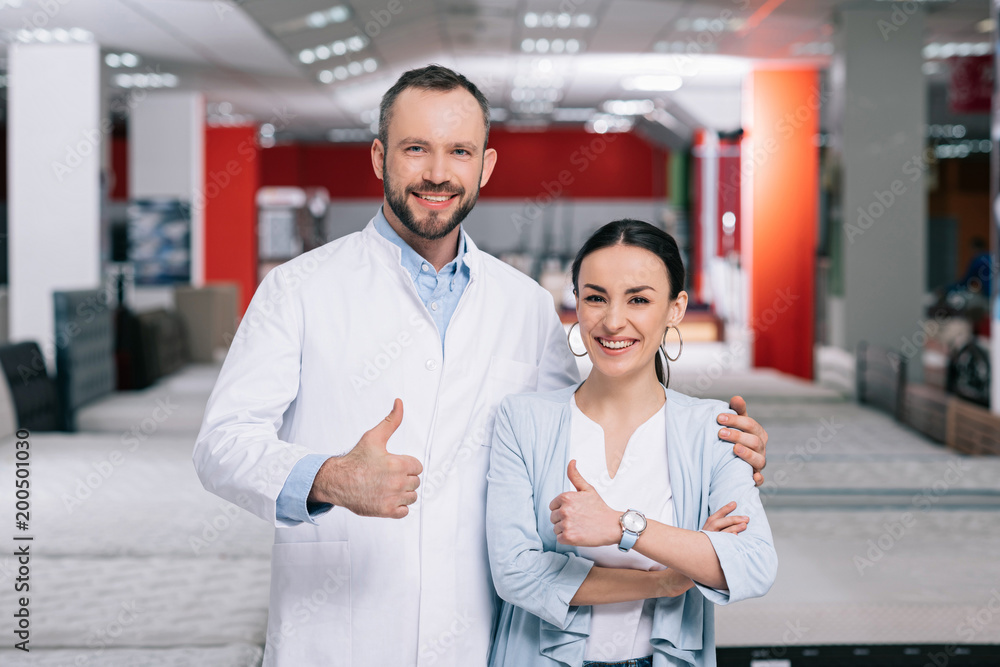 portrait of smiling customer and male shop assistant showing thumbs up in furniture store portrait of smiling customer and male shop assistant showing thumbs up in furniture store