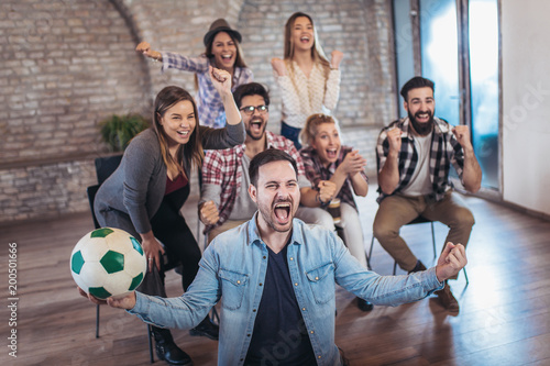 Happy friends or football fans watching soccer on tv and celebrating victory. Friendship  sports and entertainment concept.