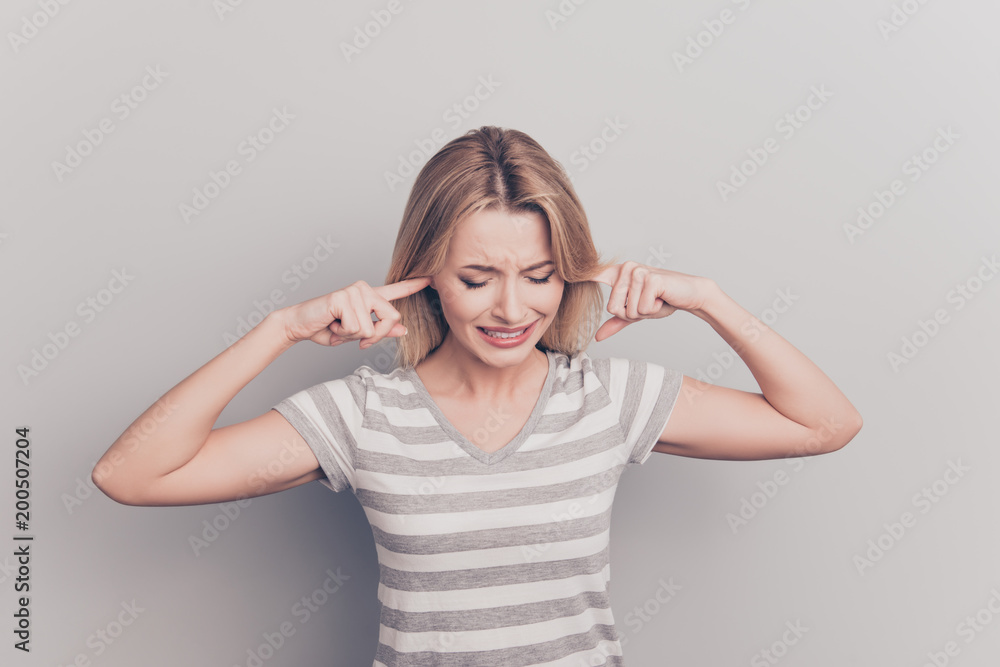 Health care healthcare feminine people person concept. Close up portrait of frustrated exhausted sad upset unhappy full of negative feelings closing ears with forefingers isolated on gray background Health care healthcare feminine people person concept. Close up portrait of frustrated exhausted sad upset unhappy full of negative feelings closing ears with forefingers isolated on gray background