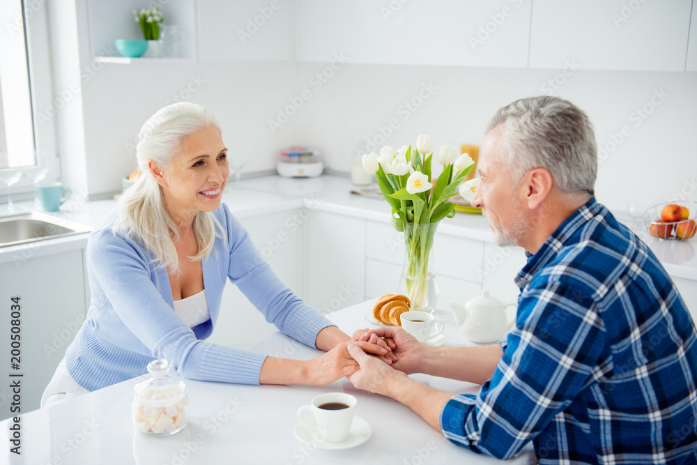 Portrait of lovely, sweet attractive stylish cheerful couple sitting at the table having brunch looking at each other holding hands, drinking coffee, enjoying time together Portrait of lovely, sweet attractive stylish cheerful couple sitting at the table having brunch looking at each other holding hands, drinking coffee, enjoying time together