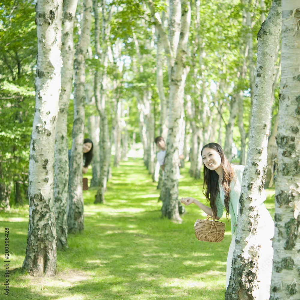 白樺の木の陰から顔を出す男女 Stock Photo Adobe Stock
