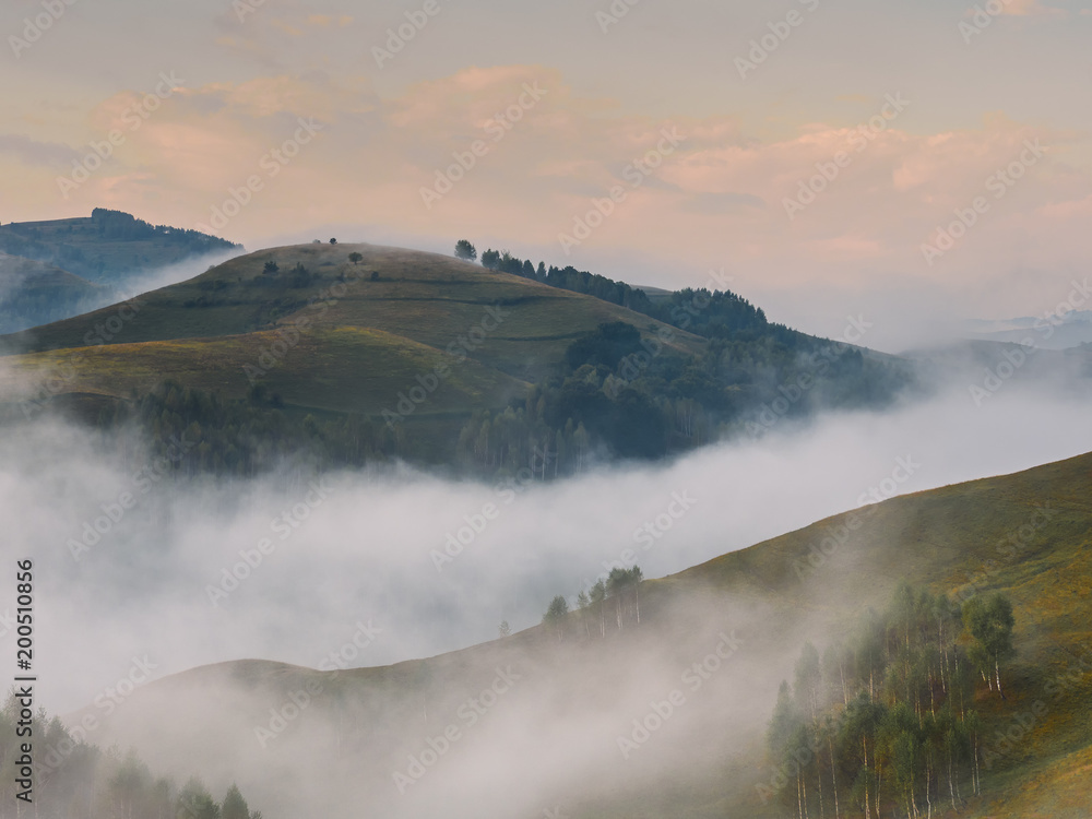 Beautiful mountain landscape of a foggy morning with trees on hills, Dumesti, Salciua, Apuseni, Romania Beautiful mountain landscape of a foggy morning with trees on hills, Dumesti, Salciua, Apuseni, Romania