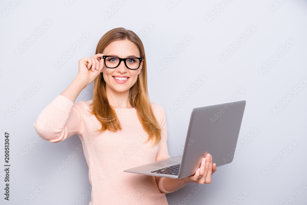 Close up portrait of confident smart intelligent clever attractive beautiful with beaming toothy shiny smile freelancer correcting eyewear holding laptop in hand isolated on gray background copy-space Close up portrait of confident smart intelligent clever attractive beautiful with beaming toothy shiny smile freelancer correcting eyewear holding laptop in hand isolated on gray background copy-space