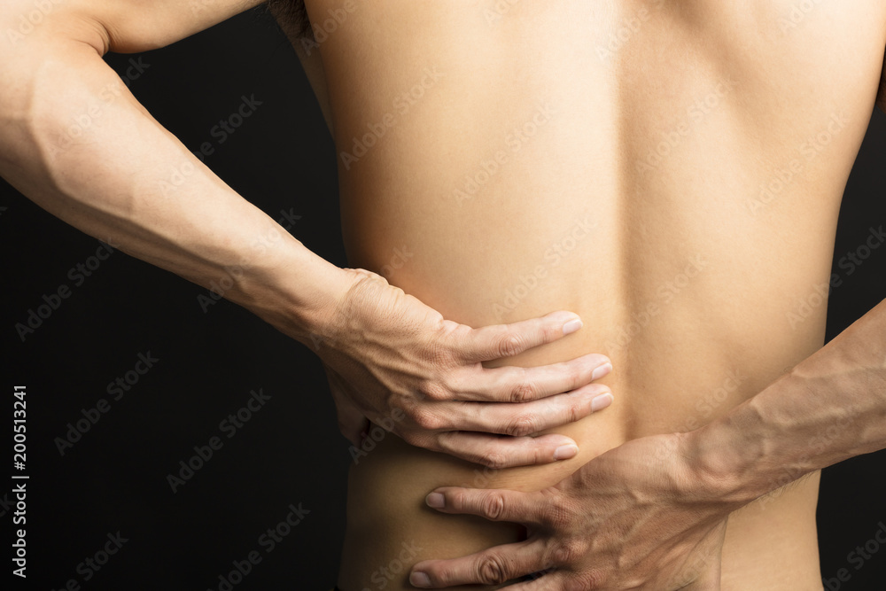 man touching his back for the pain.